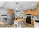 Modern kitchen with stainless steel appliances, center island and view to the living and dining areas at 4404 Oak Park Rd, Raleigh, NC 27612