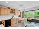 Bright kitchen featuring wood cabinets, modern appliances, an island, and a view of the outdoor greenery at 4404 Oak Park Rd, Raleigh, NC 27612