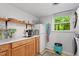 Charming laundry room featuring wood cabinets, granite counters, and a stackable washer/dryer at 4404 Oak Park Rd, Raleigh, NC 27612