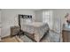 Cozy bedroom featuring a decorative quilt, bedside tables with lamps, and a large window at 48 Highview Ct, Fuquay Varina, NC 27526