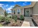 Close-up of a welcoming front entrance with stone accents, garden, and a charming green door at 48 Highview Ct, Fuquay Varina, NC 27526
