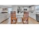 Modern kitchen with white cabinetry and stainless steel appliances, adjacent to living area with wood floors at 48 Highview Ct, Fuquay Varina, NC 27526