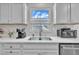 Bright kitchen features quartz countertops, white cabinetry, stainless steel appliances, and a view to the exterior at 48 Highview Ct, Fuquay Varina, NC 27526