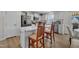 Bright kitchen with white cabinets and stainless steel appliances opens to dining area with island seating at 48 Highview Ct, Fuquay Varina, NC 27526