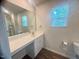 Bright bathroom with a large mirror, white vanity, and window providing natural light at 50 Teal Dr, Youngsville, NC 27596