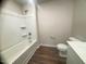 This bathroom features a tub shower, white toilet, and wood-look flooring at 50 Teal Dr, Youngsville, NC 27596