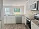 Modern kitchen with stainless steel appliances, granite countertops, and a view to the backyard at 50 Teal Dr, Youngsville, NC 27596