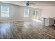 Spacious living room with wood-look floors and large windows, offering plenty of natural light at 50 Teal Dr, Youngsville, NC 27596
