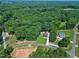 A birds-eye view captures the home's placement in a densely wooded area near winding neighborhood streets at 52 Buoy Dr, Henderson, NC 27537