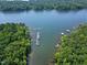 Picturesque lake with boat docks, providing immediate lake access, all surrounded by mature trees at 52 Buoy Dr, Henderson, NC 27537