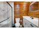 Modern bathroom showcasing marble tile, a glass shower, and a white vanity with wooden walls at 52 Buoy Dr, Henderson, NC 27537