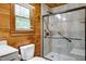 Bathroom with a walk-in shower, toilet, and window at 52 Buoy Dr, Henderson, NC 27537