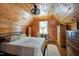 Cozy bedroom with wooden paneling, featuring a ceiling fan and window at 52 Buoy Dr, Henderson, NC 27537