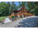 Exterior view of a log home with extensive decking and mature trees at 52 Buoy Dr, Henderson, NC 27537