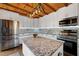 Well-lit kitchen featuring white cabinets, stainless steel appliances, and a rustic wood ceiling at 52 Buoy Dr, Henderson, NC 27537