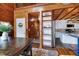 A stunning rustic kitchen features wood paneling, white cabinets, and a functional island with countertop seating at 52 Buoy Dr, Henderson, NC 27537