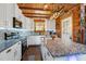Well-lit kitchen with white cabinets, stainless steel appliances, and a rustic wood ceiling at 52 Buoy Dr, Henderson, NC 27537