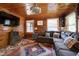 Charming living room featuring wood paneled walls, a sectional sofa, and natural light from the windows at 52 Buoy Dr, Henderson, NC 27537
