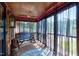 Relaxing screened porch with rustic swing, ceiling fan, and wood paneling creating a cozy outdoor space at 52 Buoy Dr, Henderson, NC 27537
