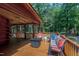 Spacious log cabin porch featuring comfortable seating, a fire pit table, and serene outdoor views at 52 Buoy Dr, Henderson, NC 27537