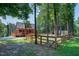 Scenic log cabin exterior with a wooden fence, lush greenery, and serene natural surroundings at 52 Buoy Dr, Henderson, NC 27537