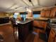 Kitchen island with granite countertop with wood cabinets with view to breakfast table and living area at 5456 Thunderidge Dr, Raleigh, NC 27610