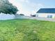 Backyard featuring a retaining wall, green grass and a white fence at 5849 Ricker Rd, Raleigh, NC 27610