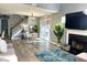 Bright living room featuring a cozy fireplace, open staircase, and a glass sliding door at 5849 Ricker Rd, Raleigh, NC 27610