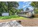 Exterior view of the house and backyard featuring a lush lawn, siding, shed, and mature trees at 709 Brighton Rd, Raleigh, NC 27610