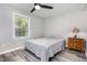 Bedroom featuring a comfortable bed, side table, and natural light from the window, complimented by grey flooring at 709 Brighton Rd, Raleigh, NC 27610