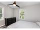 Bright bedroom featuring natural light, modern ceiling fan, black dresser, and a comfortable bed with grey flooring at 709 Brighton Rd, Raleigh, NC 27610