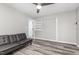 Bedroom with grey floors, black futon, and view into dining area and built in white storage shelves at 709 Brighton Rd, Raleigh, NC 27610