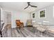 Dining room with modern ceiling fan, grey floors, and bright natural light from surrounding windows at 709 Brighton Rd, Raleigh, NC 27610