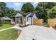Inviting home with a new walkway and concrete driveway nestled among lush trees at 709 Brighton Rd, Raleigh, NC 27610