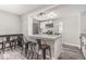 Kitchen bar area with granite countertops, seating, stainless steel appliances, and grey wood-look flooring at 709 Brighton Rd, Raleigh, NC 27610