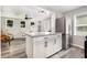 Updated kitchen with white cabinetry, granite countertops, stainless steel appliances, and grey wood-look flooring at 709 Brighton Rd, Raleigh, NC 27610