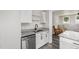 Modern kitchen featuring granite countertops, stainless steel appliances, white cabinets, and grey wood-look floors at 709 Brighton Rd, Raleigh, NC 27610