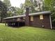 Brick home featuring a wooden deck with a chimney and backyard at 7194 Johns Point Ct, Liberty, NC 27298