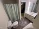 Bright bathroom features a shower with a curtain, a single vanity with a large mirror, and wood look floors at 7194 Johns Point Ct, Liberty, NC 27298