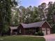 Charming brick home with a well-maintained lawn and mature trees surrounding the property at 7194 Johns Point Ct, Liberty, NC 27298