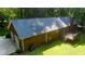 Aerial shot of a brick home with a chimney, two-car garage and deck nestled amongst the trees at 7194 Johns Point Ct, Liberty, NC 27298