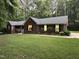 Brick home with large front lawn and a well-manicured landscape and mature trees around the property at 7194 Johns Point Ct, Liberty, NC 27298