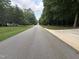 Street view with the paved road leading away from the property at 7194 Johns Point Ct, Liberty, NC 27298