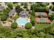 Aerial view of community pool, tennis courts, and clubhouse surrounded by manicured landscaping at 8106 Sommerwell St, Raleigh, NC 27613