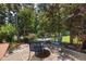 Charming backyard patio features a table and chairs surrounded by lush landscaping and natural stone paving at 8106 Sommerwell St, Raleigh, NC 27613