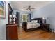 Charming bedroom with a sleigh bed, wood floors, and a ceiling fan at 8106 Sommerwell St, Raleigh, NC 27613