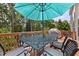 Outdoor deck with dining table, chairs, a shade umbrella, and a grill overlooking the trees at 8106 Sommerwell St, Raleigh, NC 27613