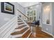 Elegant entryway featuring hardwood floors, a staircase, and a glimpse of the living room's bright windows at 8106 Sommerwell St, Raleigh, NC 27613