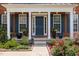 Charming front porch with blue door, decorative plants, and tasteful landscaping enhancing curb appeal at 8106 Sommerwell St, Raleigh, NC 27613