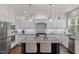 Modern kitchen with stainless steel appliances, granite countertops, island with seating and pendant lights at 8106 Sommerwell St, Raleigh, NC 27613